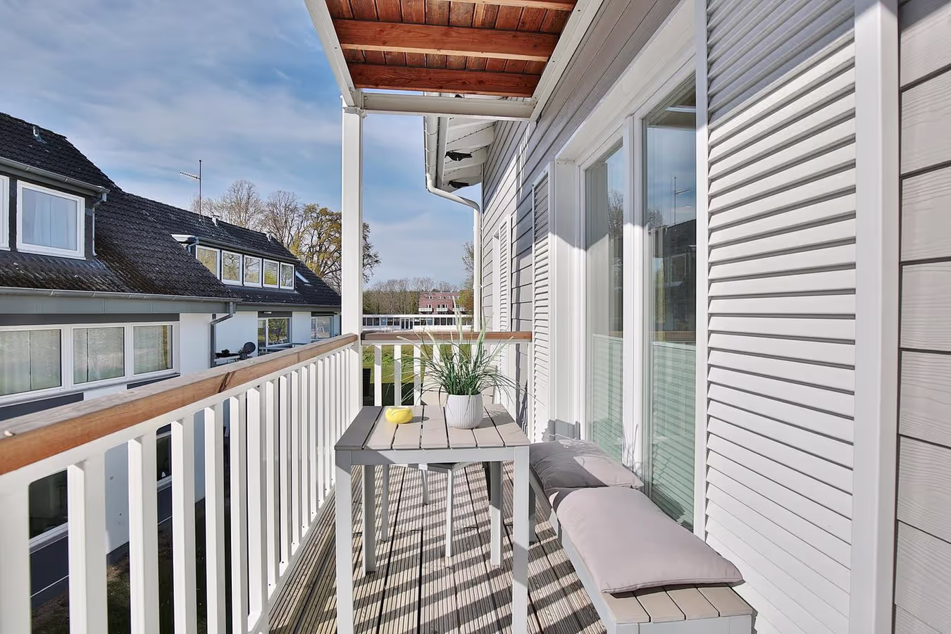 Sonniger Balkon der Ferienwohnung Meeresbrise mit Sitzbank und Tisch