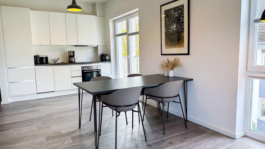 Weiße offene Küche mit Esstisch in der Ferienwohnung