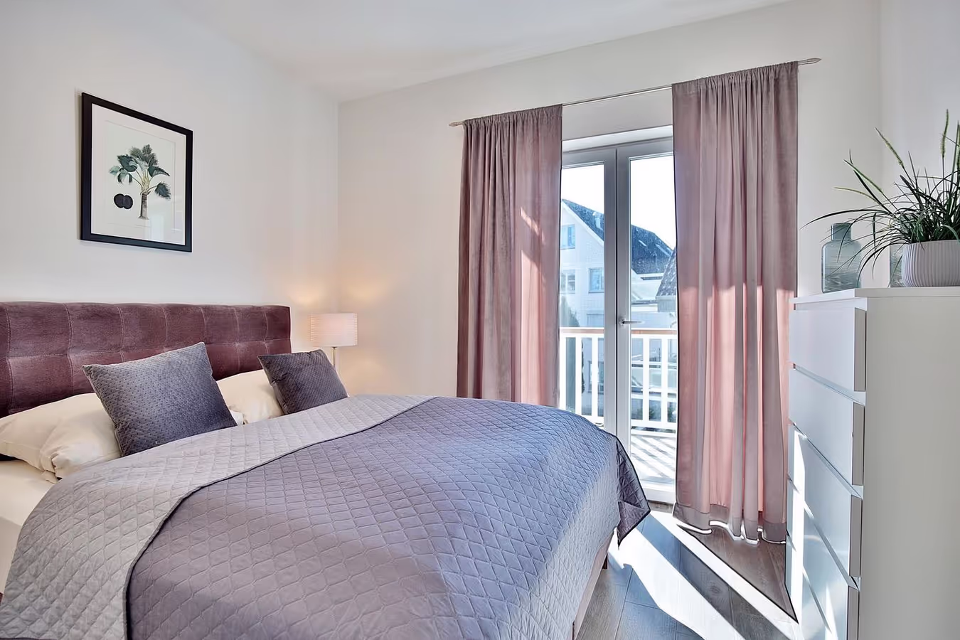 Schlafzimmer der Ferienwohnung mit Doppelbett und Zugang zum Balkon