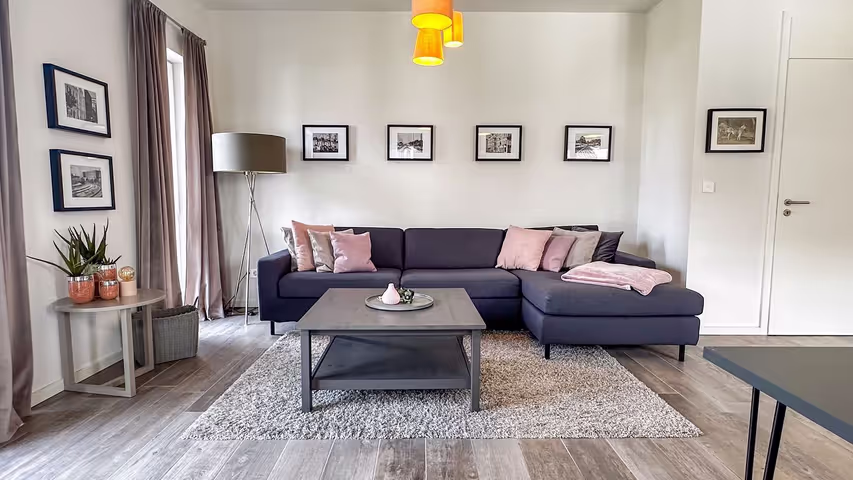 Gemütlicher Wohnbereich mit Ecksofa und maritimen Bildern